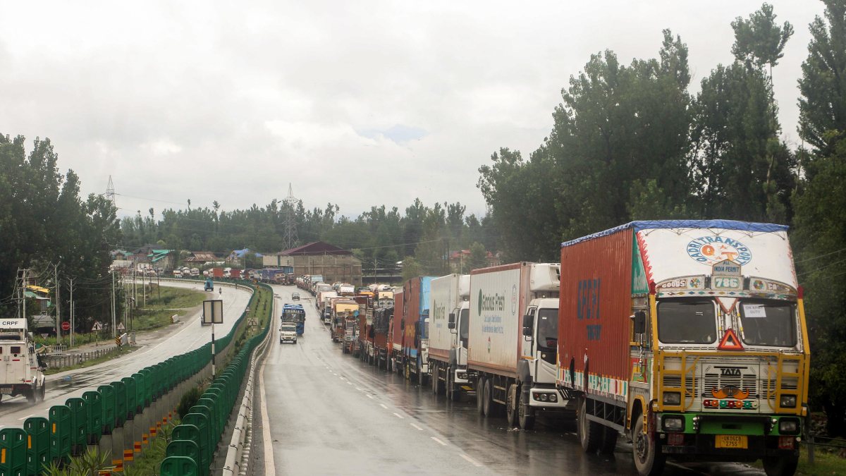 Trucks and other vehicles wait for traffic resume and road reopen following the…