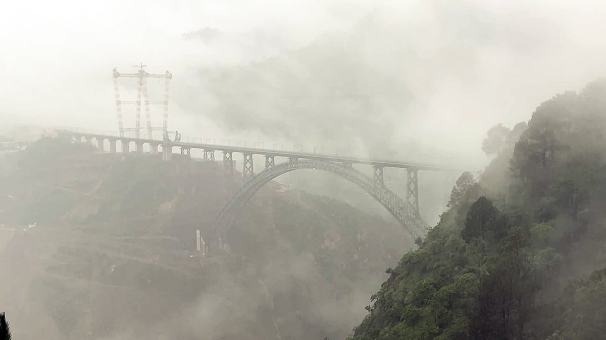 A view of the Chenab Rail Bridge covered in dense fog, in Reasi on Friday. (ANI…