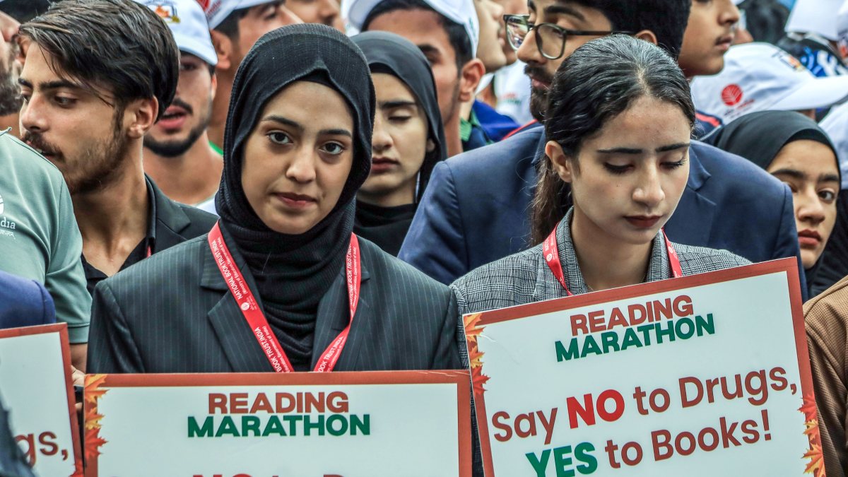 Volunteers with "Say NO To Drugs, YES to Books!" placards walk during the…