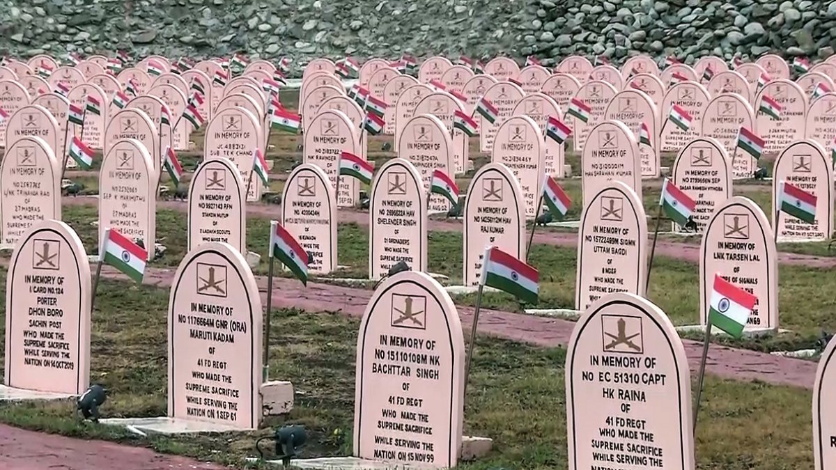 A view of rows of memorial headstones adorned with National flags as…