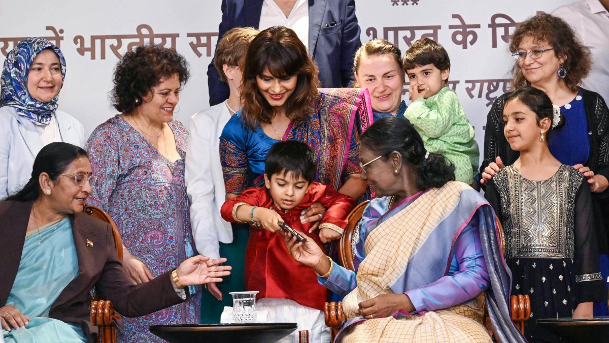 President Droupadi Murmu offers a chocolate to a child during a reception with…