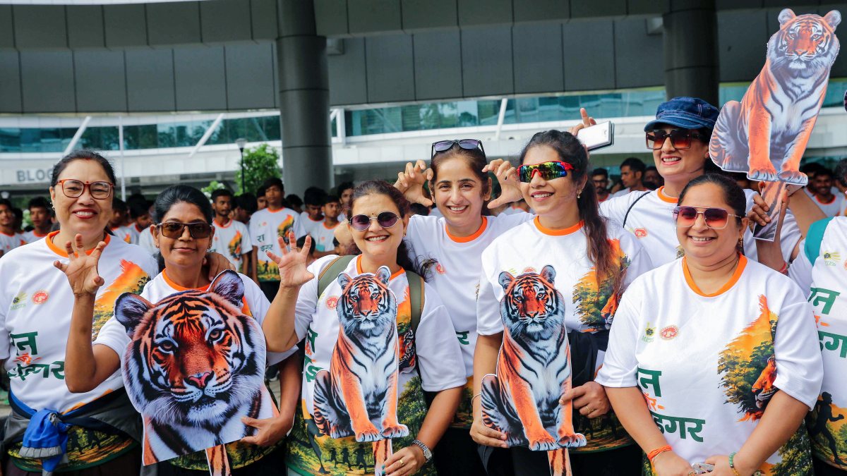 Participants with cut-outs of tiger pose for group photograph during a 'Run for…