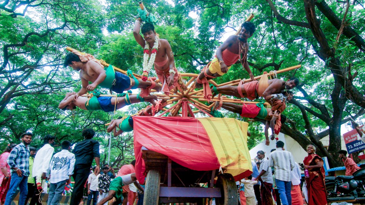 Hindu devotee spins child from pole with hooks in back during Aadi festival