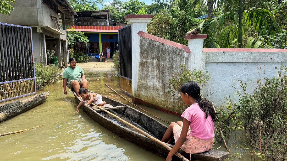 Children use boat in flood-hit Sivasagar residential area