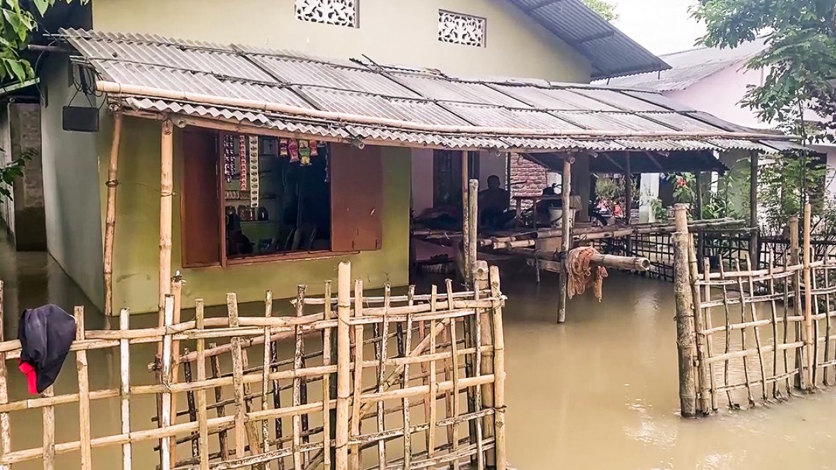 Floodwaters engulf a house in Sivasagar's Naujan village