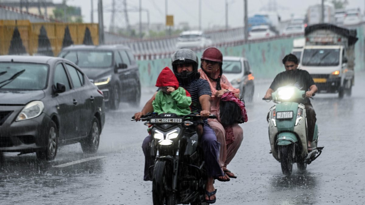 Commuters wade through waterlogged Delhi roads amid heavy rain