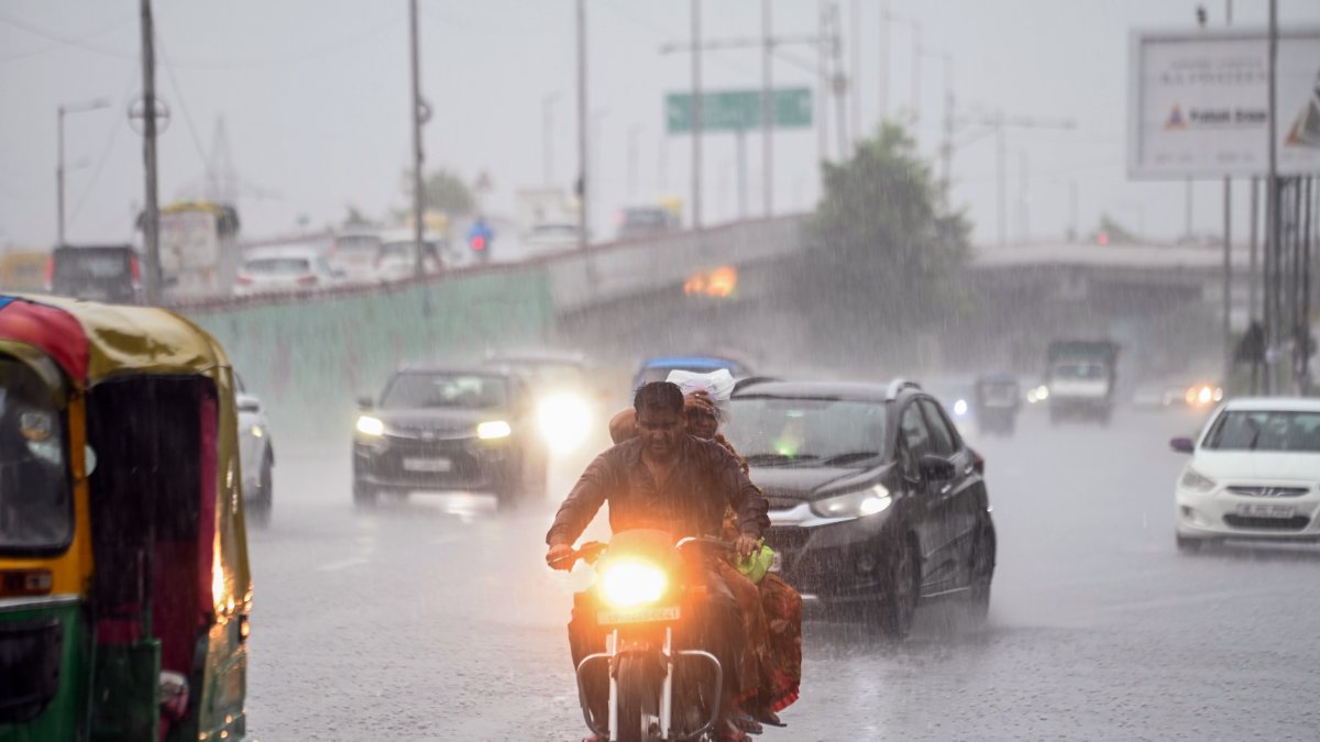 Commuters wade through waterlogged Delhi roads amid heavy rain