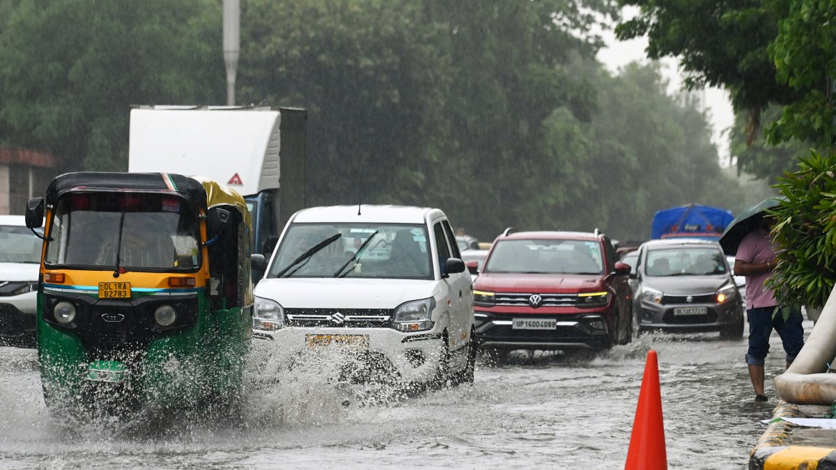 Commuters wade through waterlogged Janpath in New Delhi