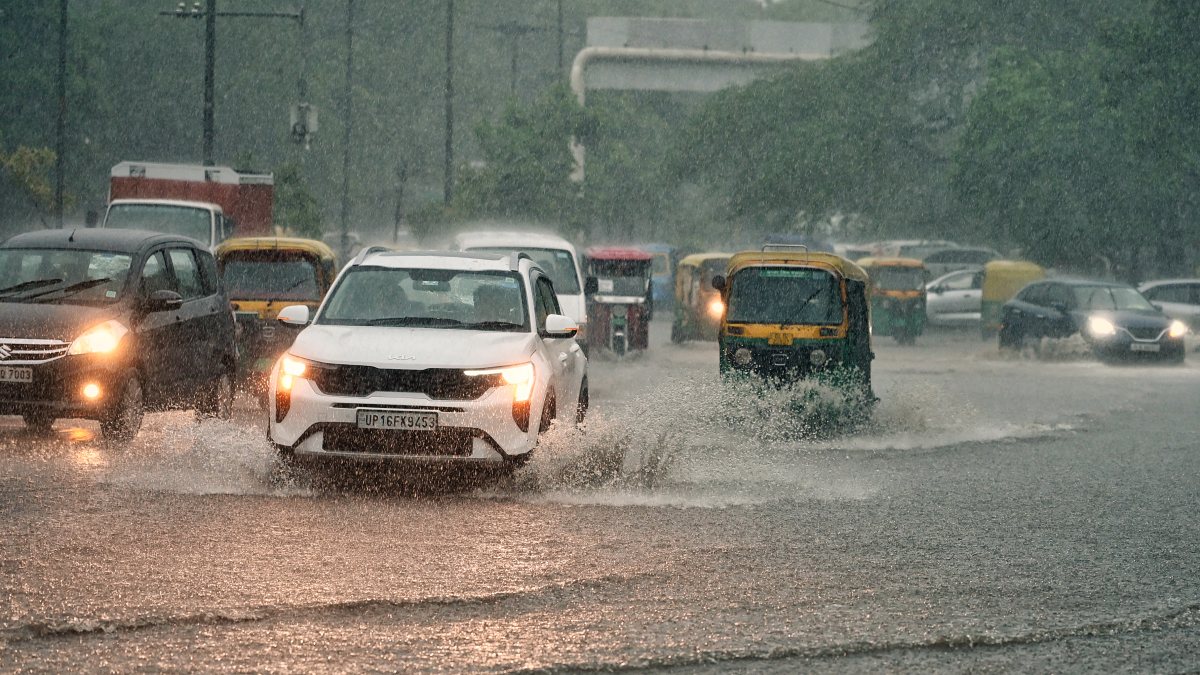 Commuters wade through waterlogged road in Delhi amid heavy rain