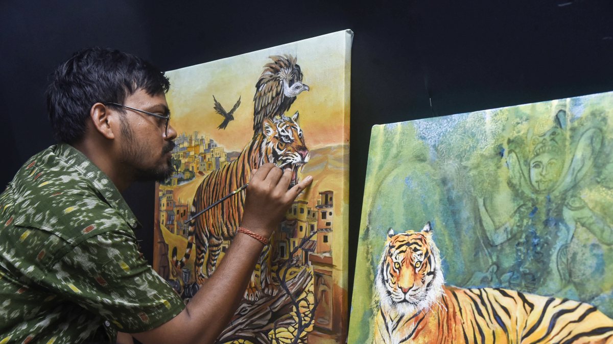Artist adds final touches to tiger painting for International Tiger Day