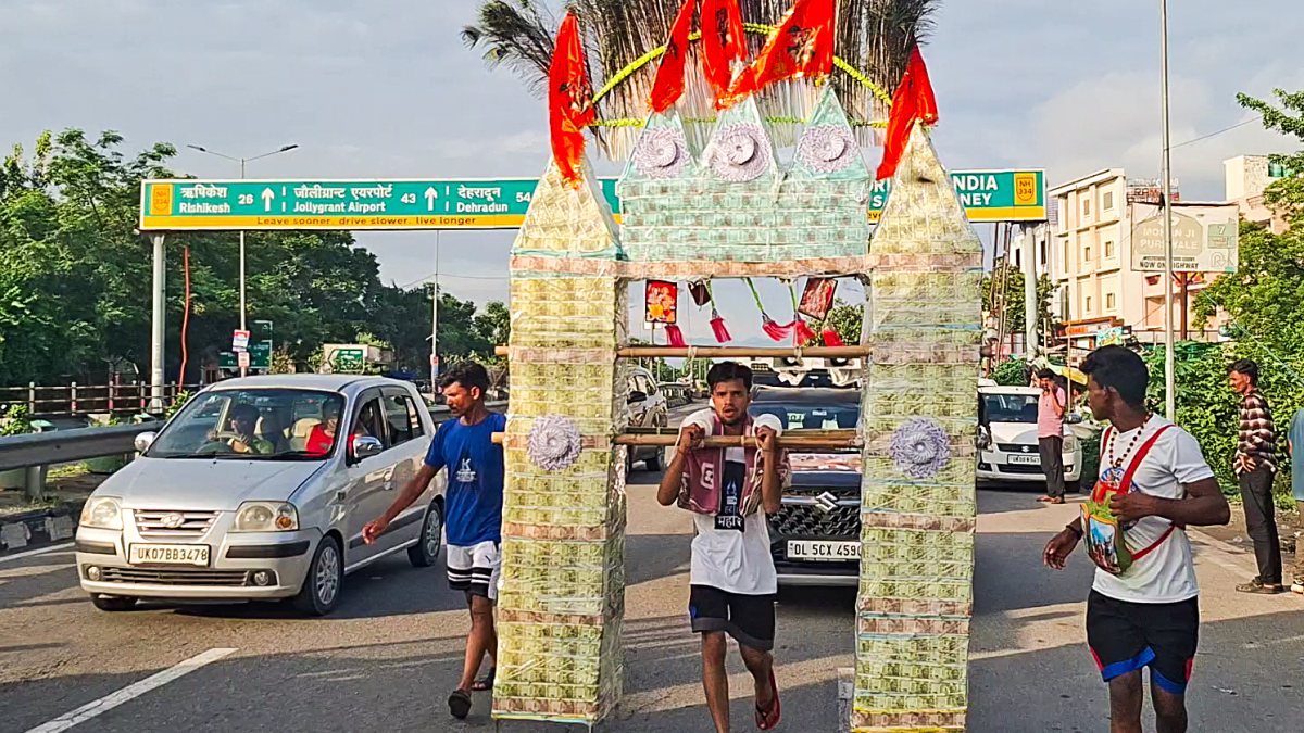 Devotee carries Kanwar decorated with currency notes in Haridwar