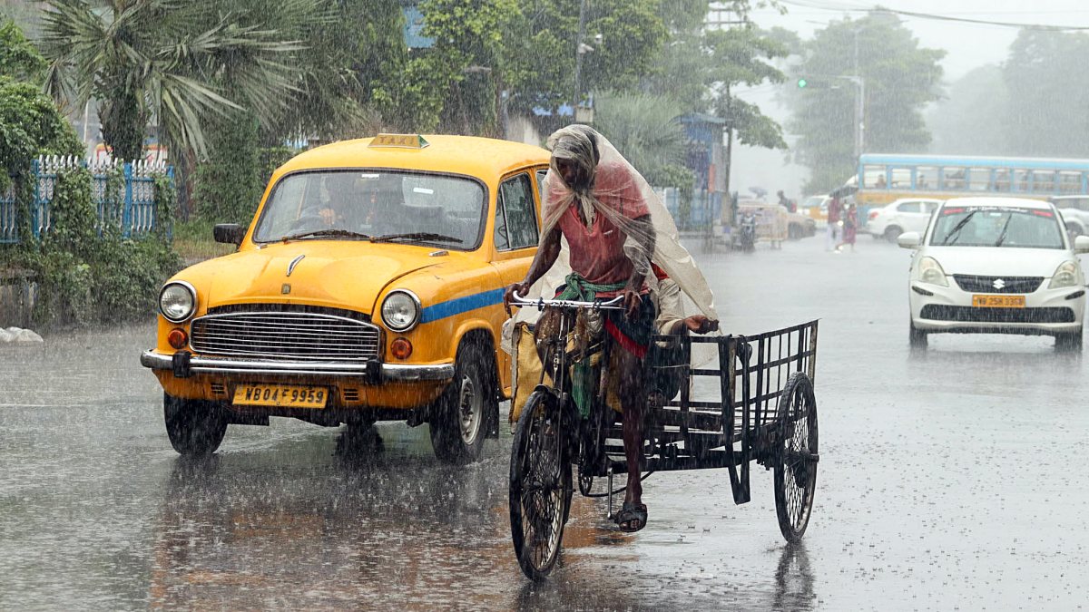 Commuters wade through waterlogged Kolkata streets amid rain