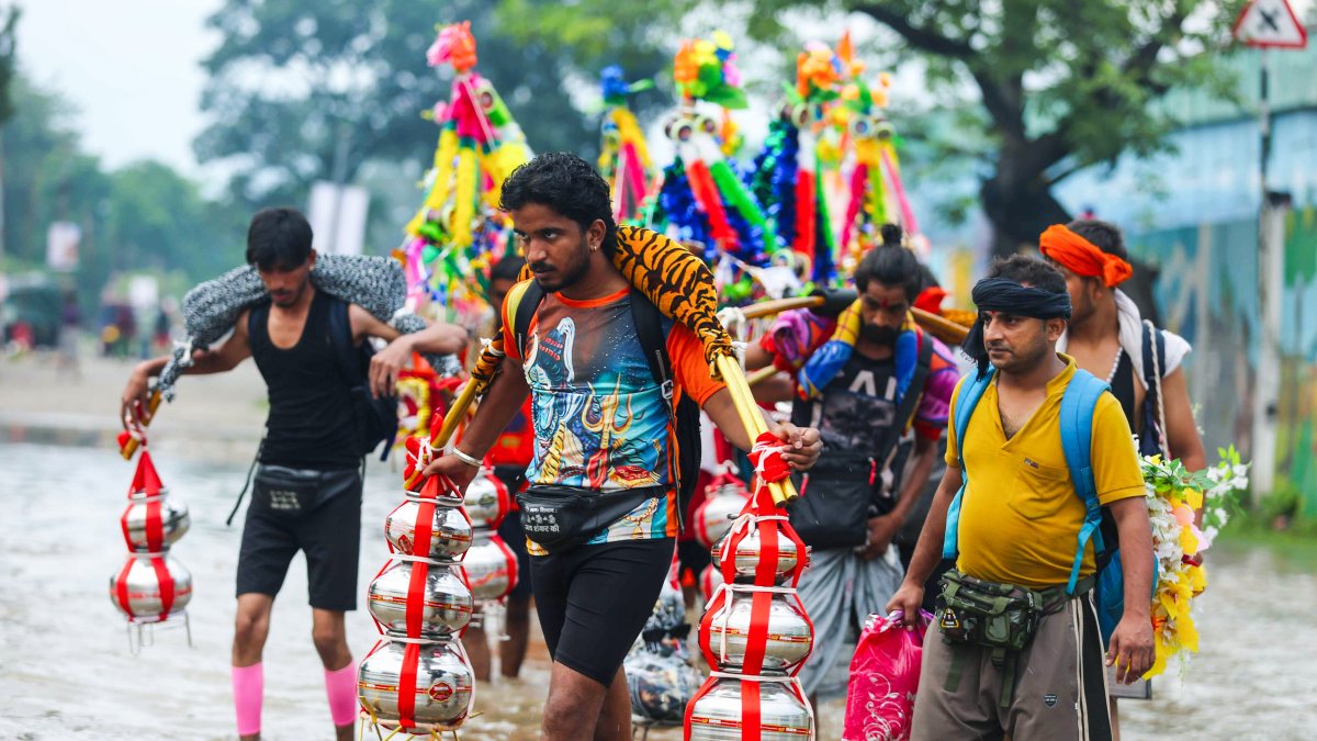 Devotees carry kanwars through waterlogged Haridwar streets amid rain