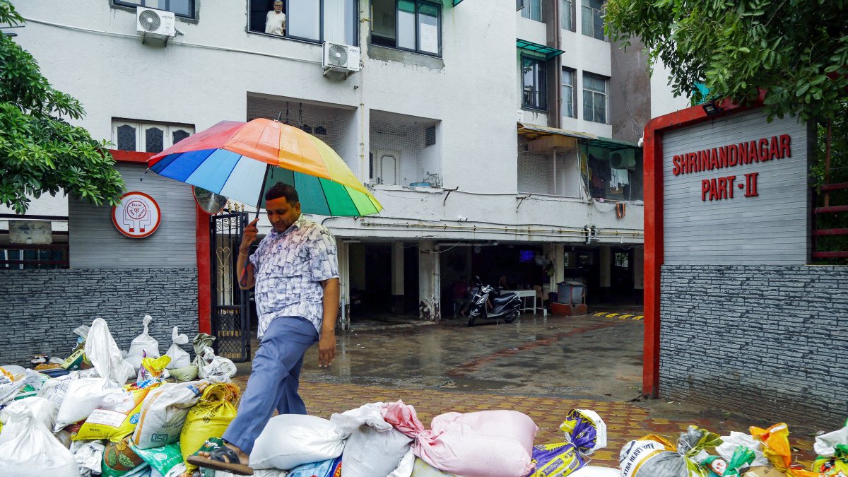 Ahmedabad residents cross sandbag barrier amid heavy rainfall