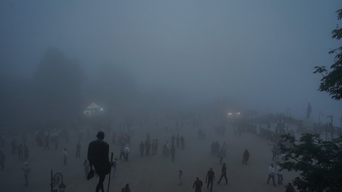 Tourists stroll through dense fog in Shimla