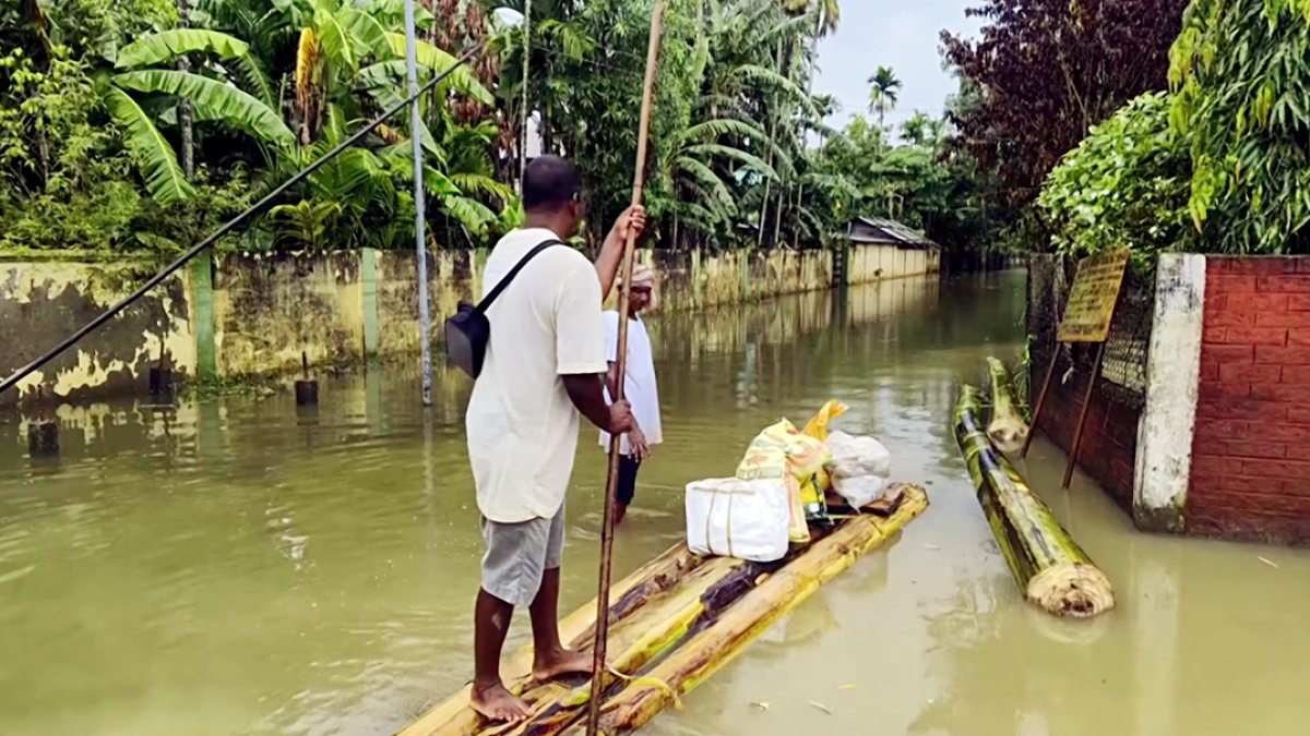 A Lok Janshakti Party (Ramvilas) worker carries food supplies on a banana raft…
