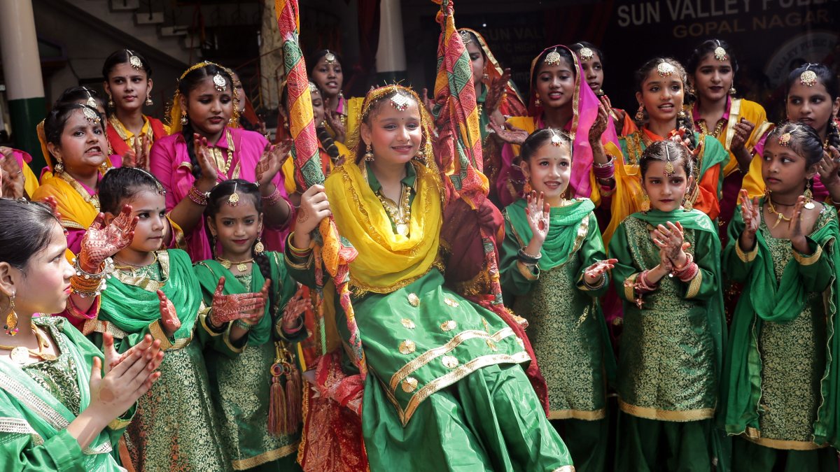 Schoolgirl in traditional attire enjoys swing at Teej festival