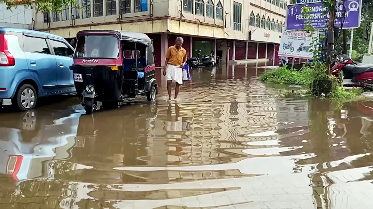 Kerala rains: commuter wades through flooded Kottayam street
