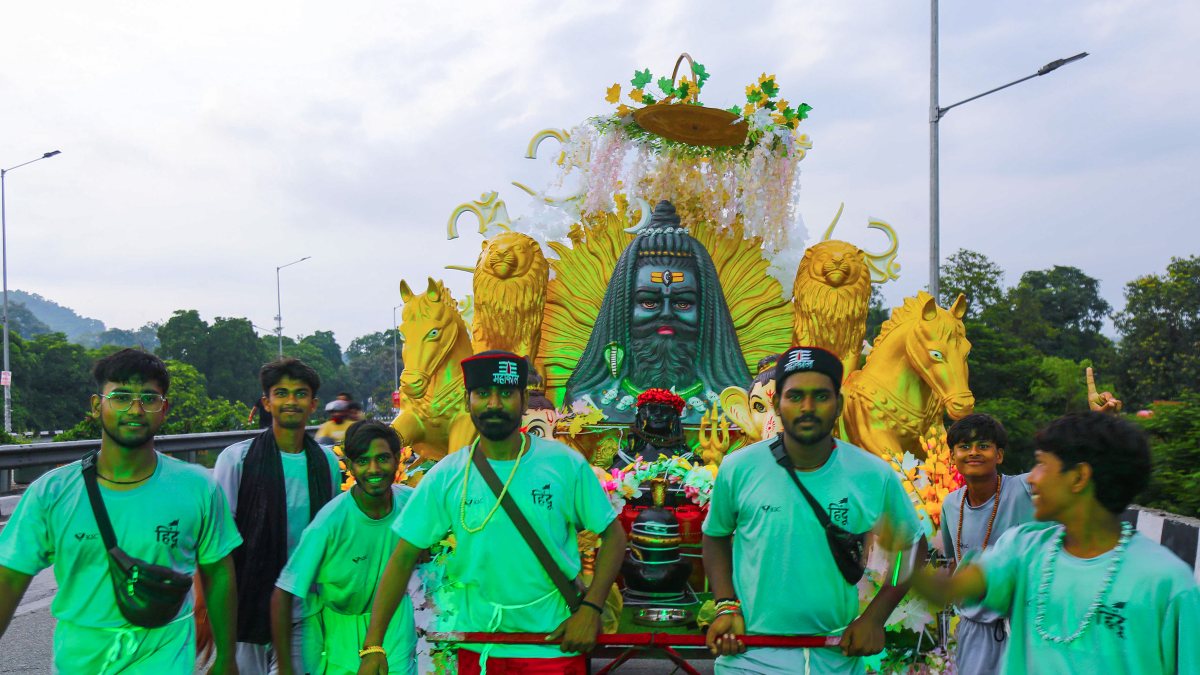 Devotees carry decorated Kanwar with Shiva statue in Haridwar