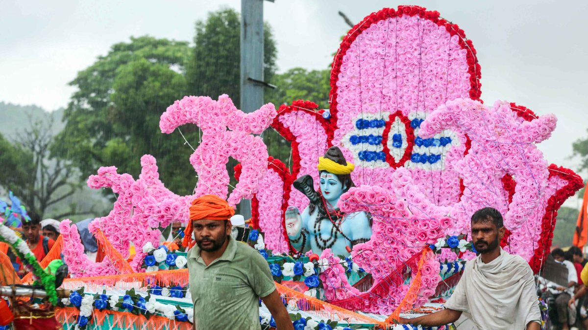 Devotees carry Lord Shiva idol amid rain during Kanwar Yatra