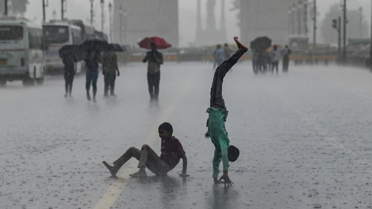 Children play in rain near Kartavya Path in New Delhi