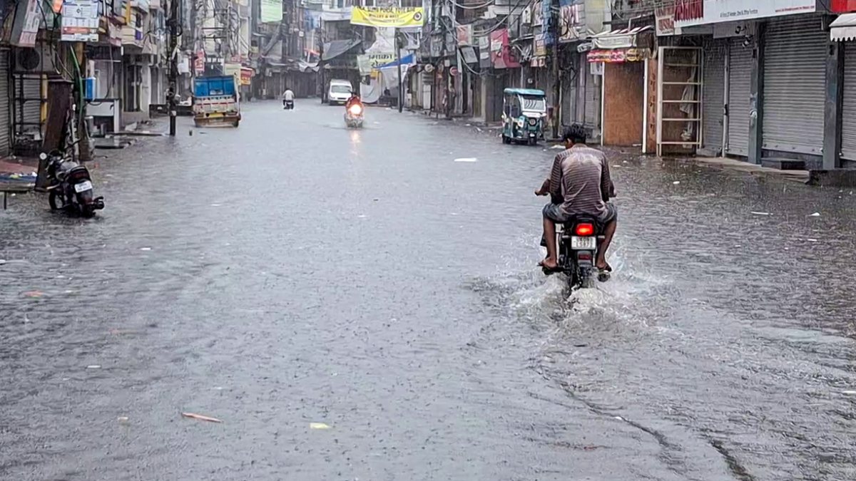 Haridwar commuters wade through waterlogged street after heavy rain
