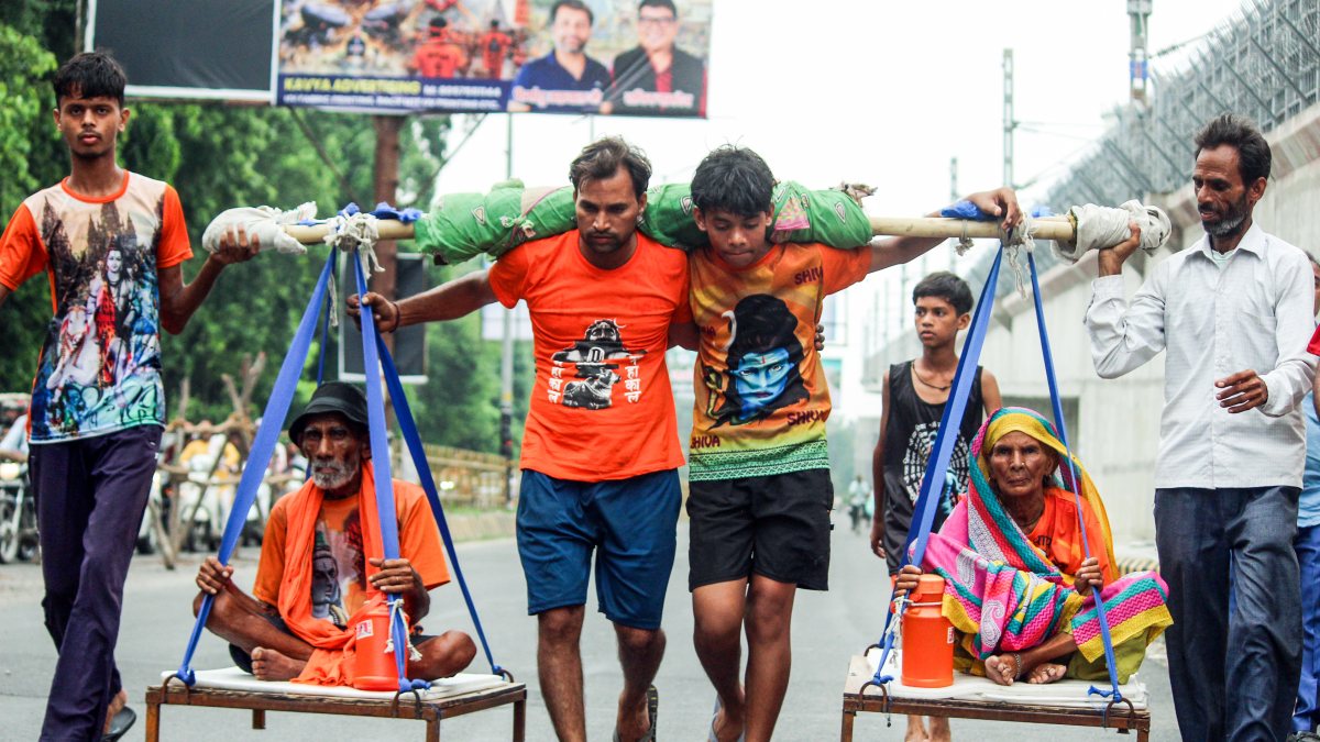 Devotees carry elderly couple on palanquin during Kanwar Yatra in Meerut
