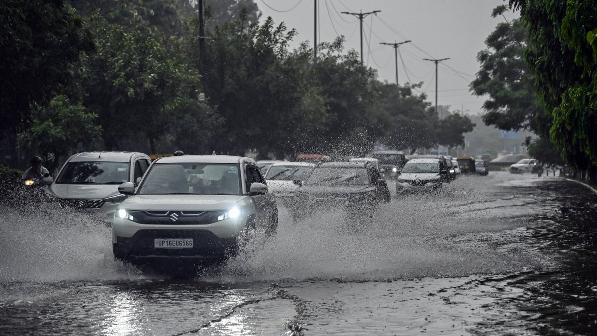 Commuters wade through waterlogged Delhi road amid heavy rain