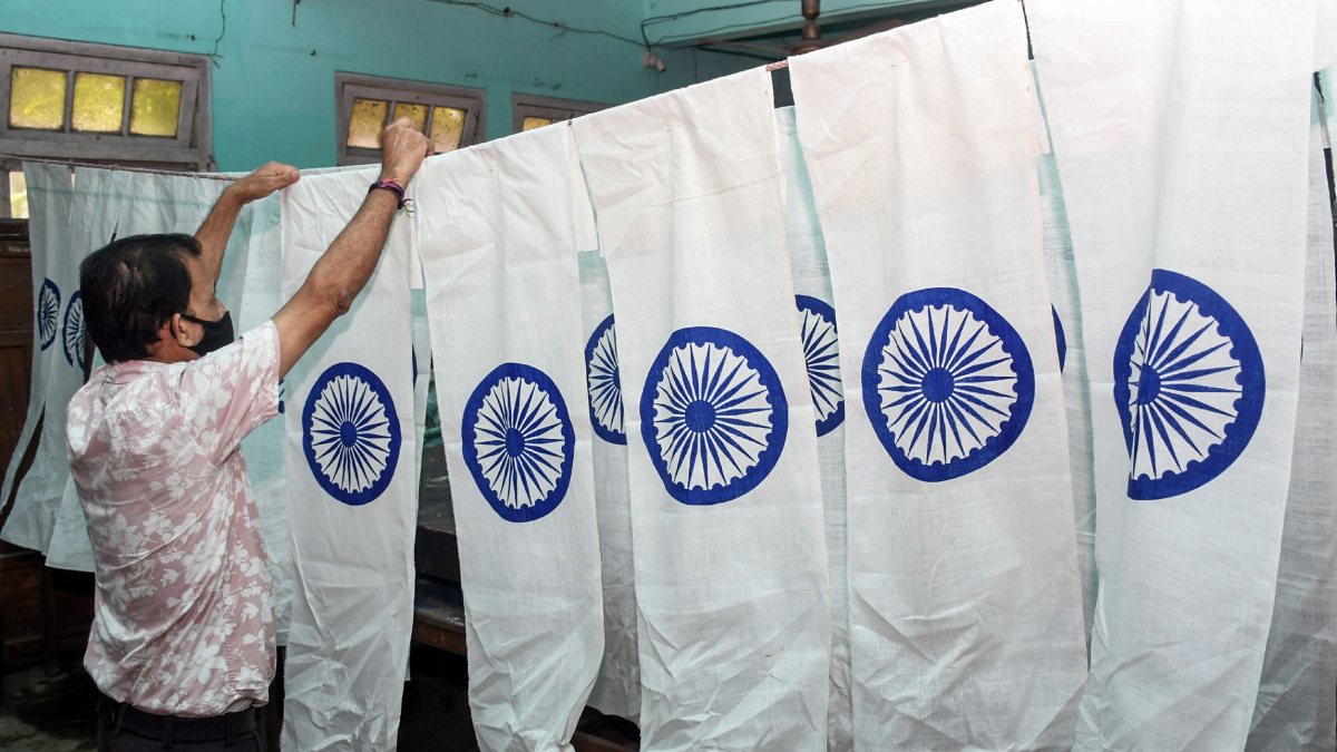 Assam board employee dries fabric for Independence Day flags