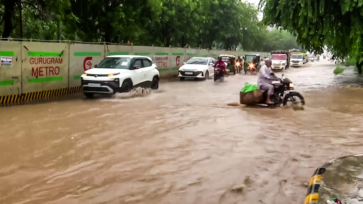 Gurugram commuters wade through waterlogged road after heavy rain
