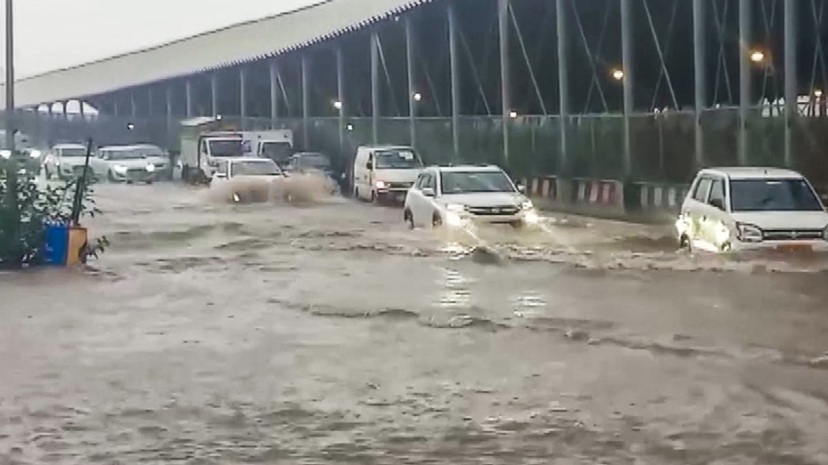 Commuters wade through waterlogged road at Kapashera Border in Delhi