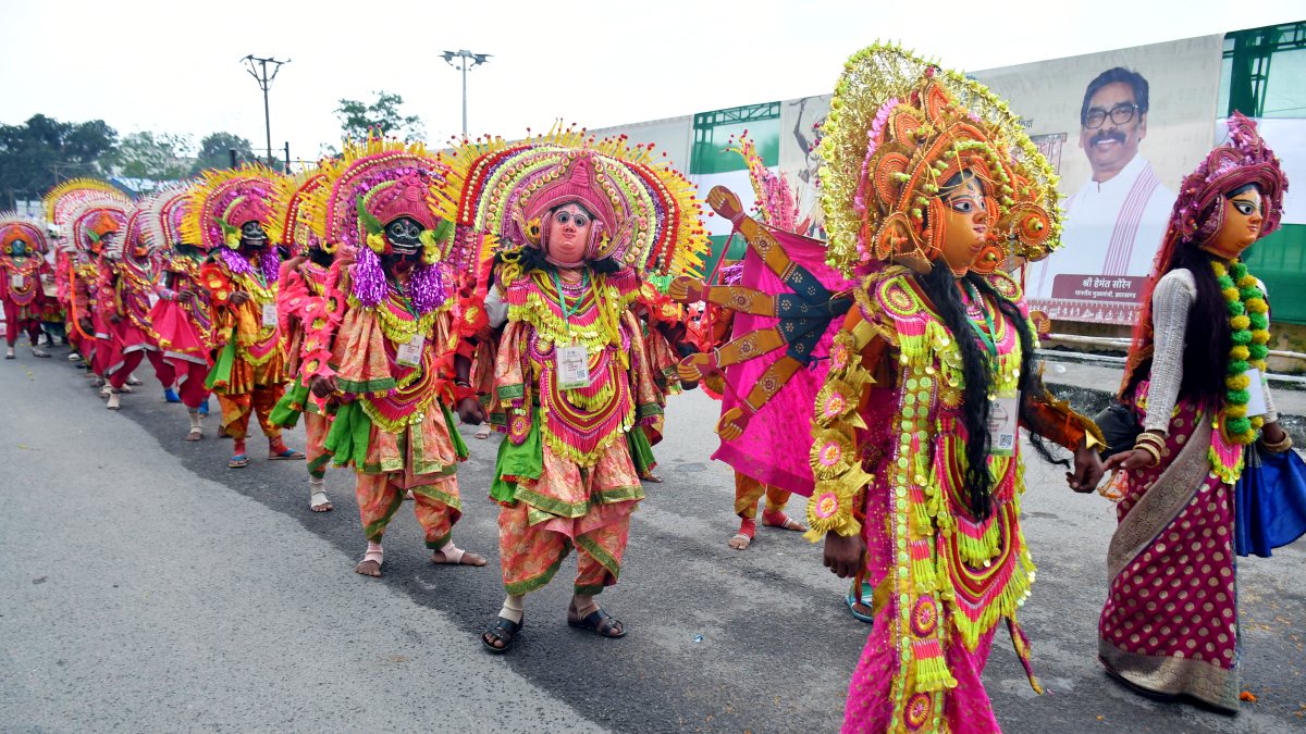 Tribal men and women dressed in traditional Adivasi attire play traditional…