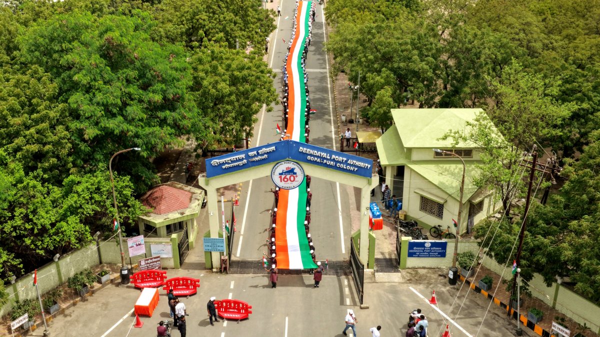 School students hold a long Tri-color flag in the Tiranga Yatra as DPA Kandla…