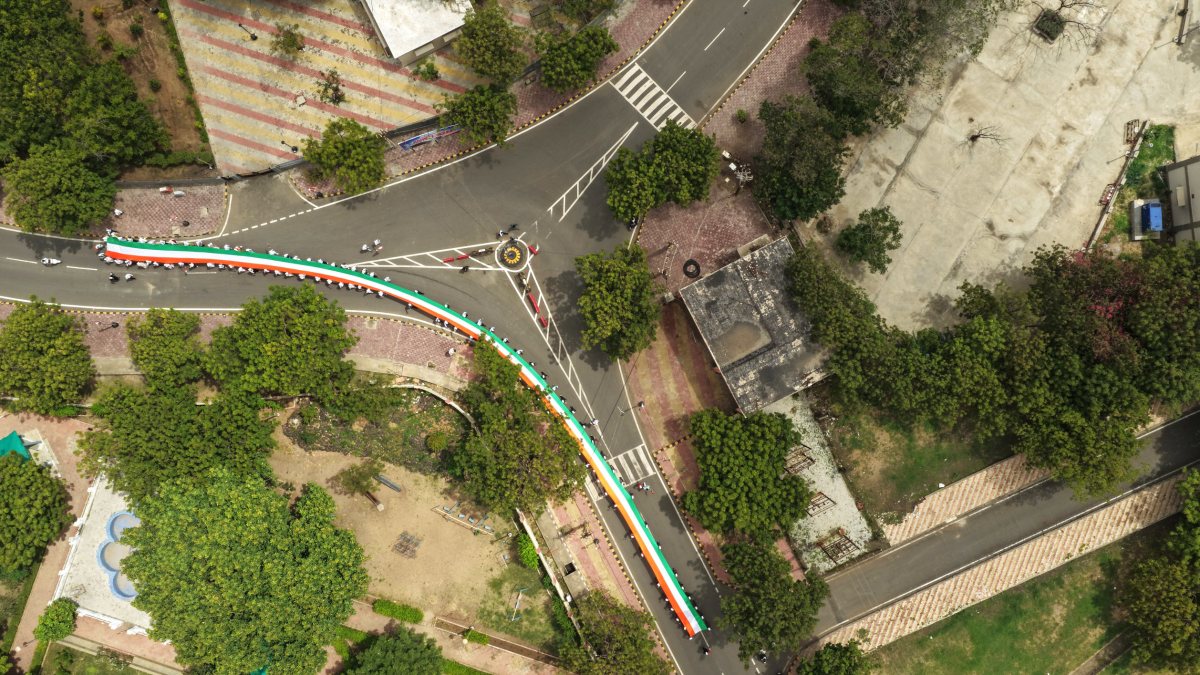 A drone view of school students holding a long Tri-color flag in the Tiranga…
