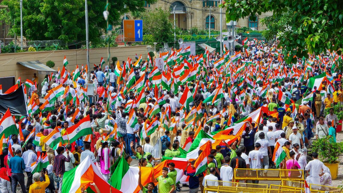 People with flags in their hands participate in the "Tiranga Yatra" led by UP…
