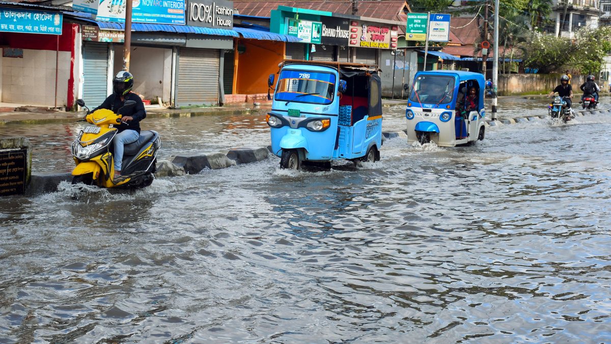 Guwahati commuters wade through waterlogged Rukminigaon after heavy rain