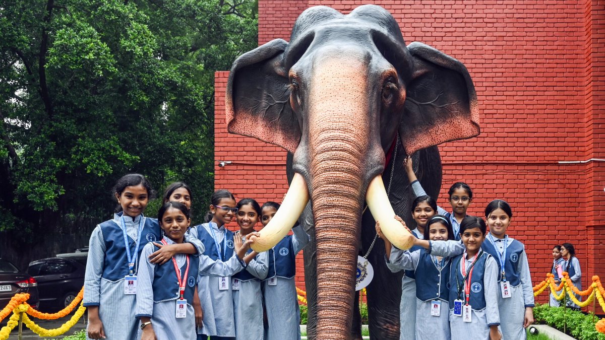 School kids pose with elephant statue on World Elephant Day
