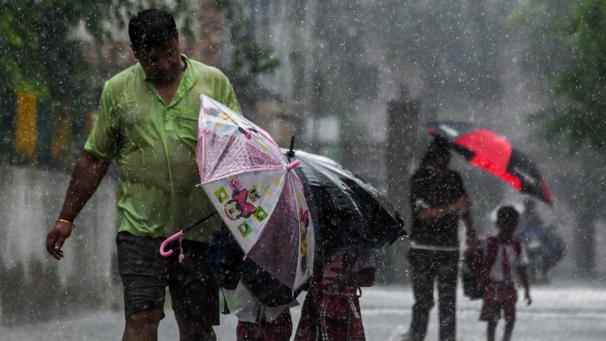 Heavy rain forces father to shield children with umbrellas in Ghaziabad