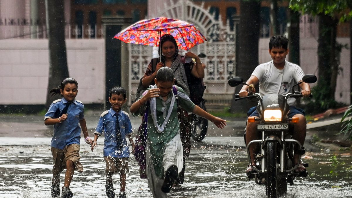 Students play in waterlogged road after heavy rain in Ghaziabad