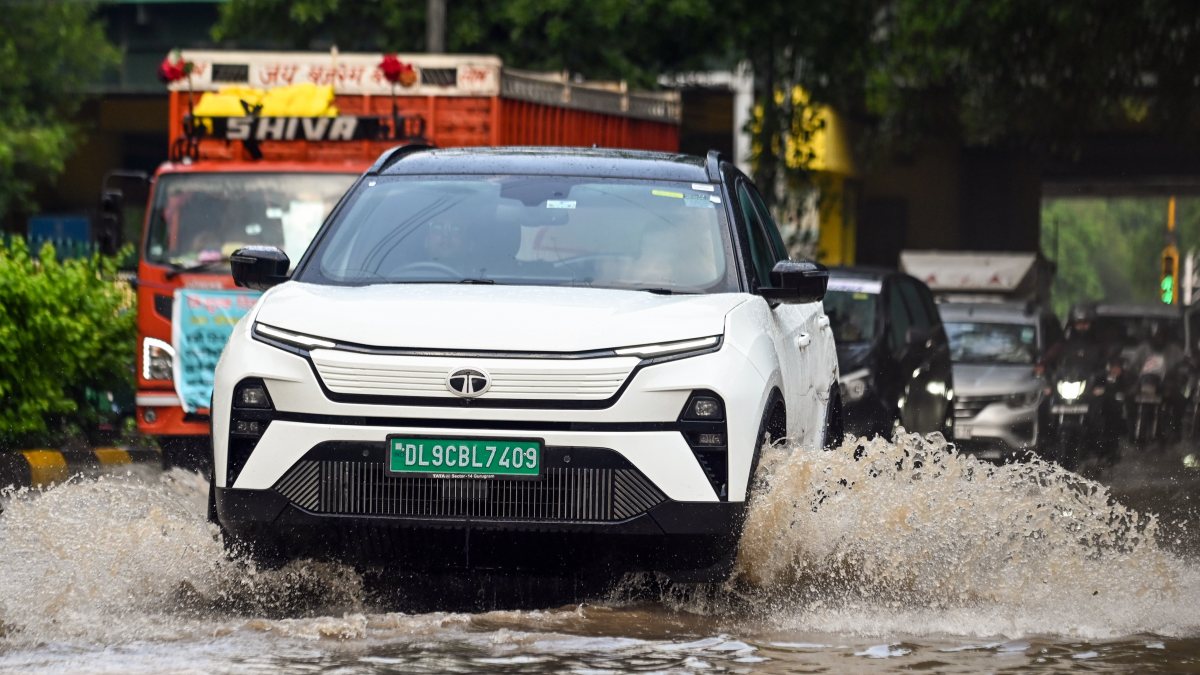 Commuters wade through waterlogged road after heavy rain in Ghaziabad