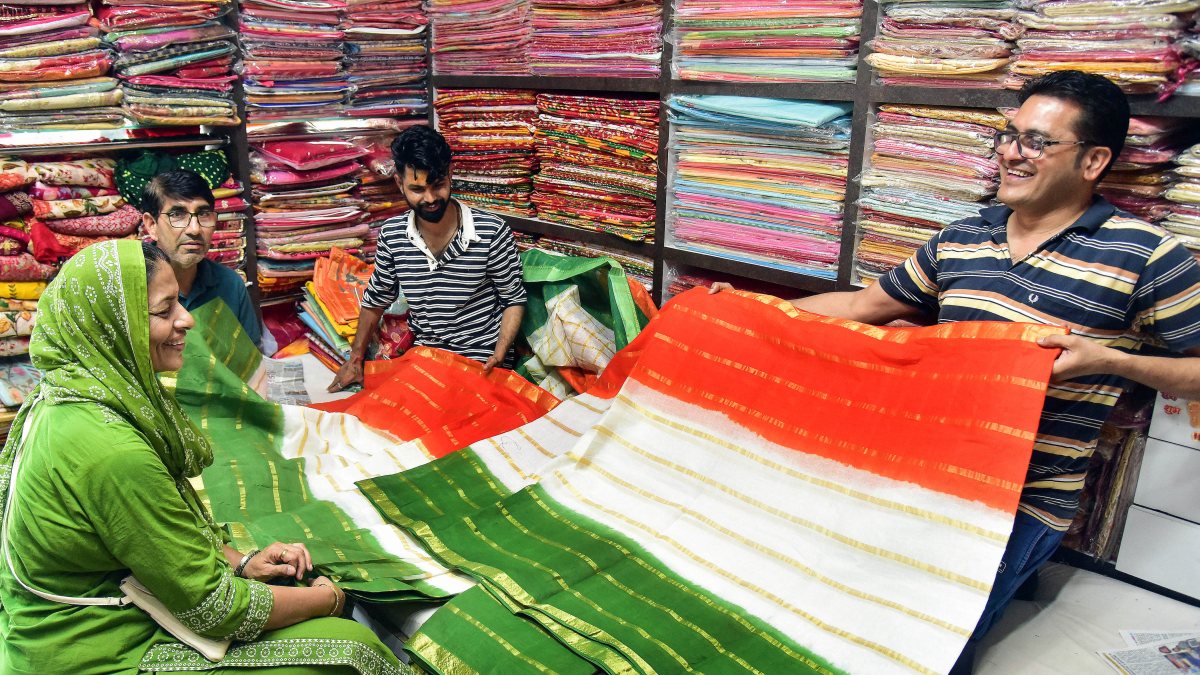 Shopkeeper shows tricolour saree to customer in Bikaner