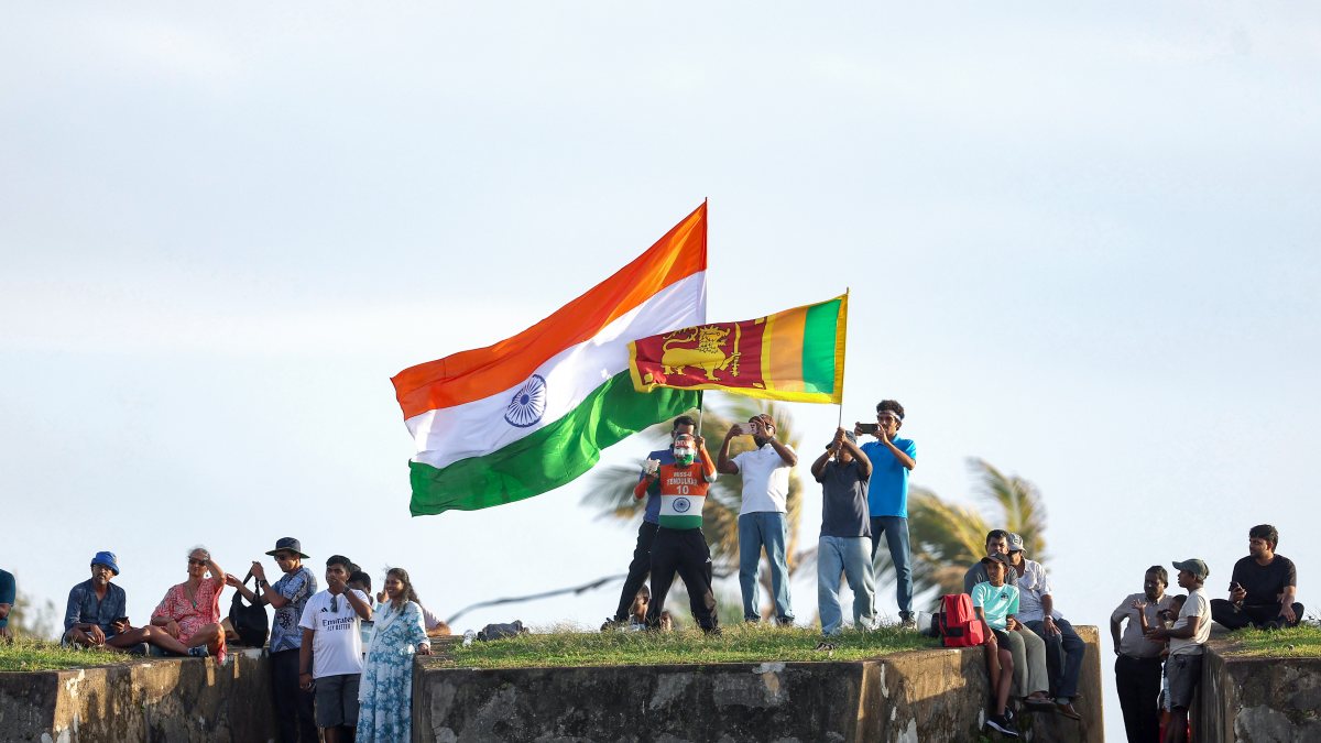 Indian and Sri Lankan fans wave flags from Galle Fort during Test