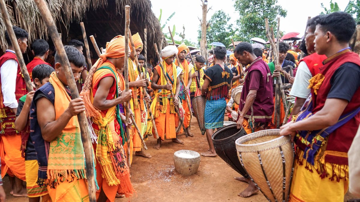 Tiwa tribal men pound rice at Wanshuwa festival in Karbi Anglong