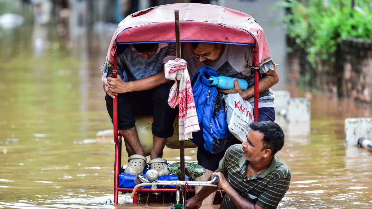 Guwahati rickshaw puller wades through flooded street after heavy rain
