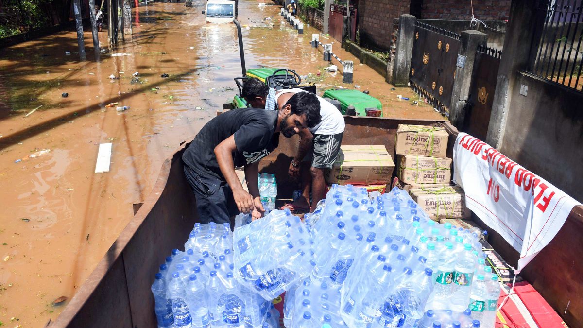 Guwahati workers load relief materials for waterlogging victims