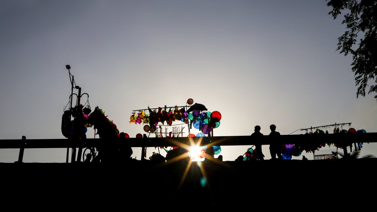 Silhouette of balloon vendor during Dashama idol immersion in Ahmedabad