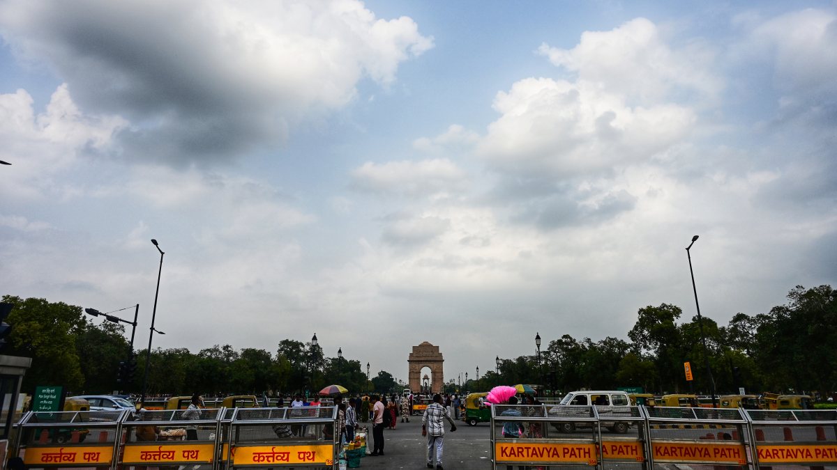 Dark clouds loom over India Gate as visitors enjoy Delhi weather