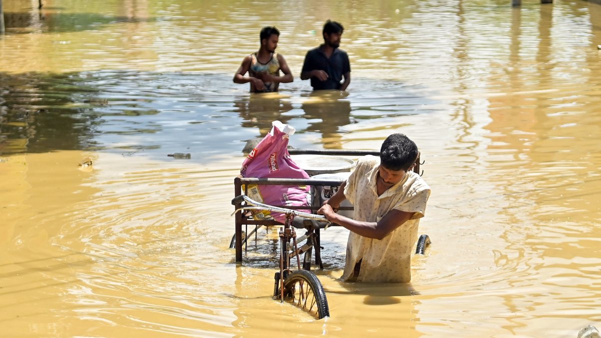 Flood-hit villagers wade through water to safety in Agartala