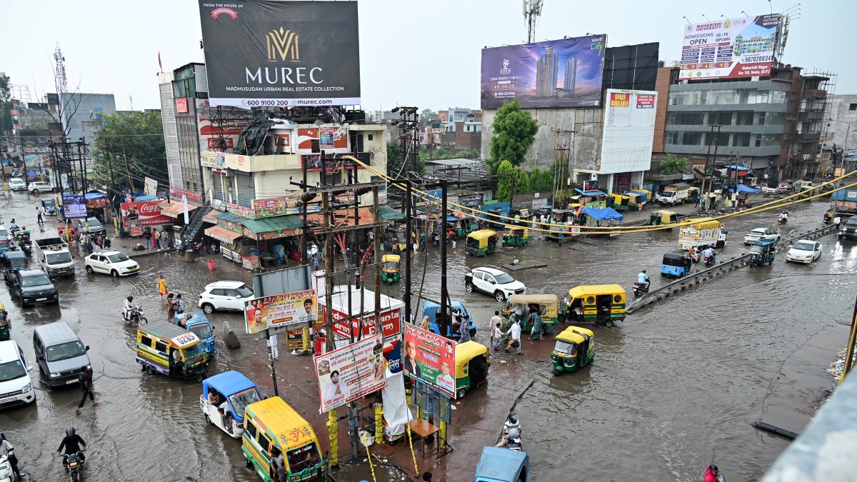 Commuters wade through waterlogged road amid traffic jam in Ghaziabad