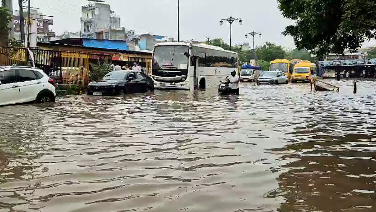Gurugram commuters wade through waterlogged road after heavy rain